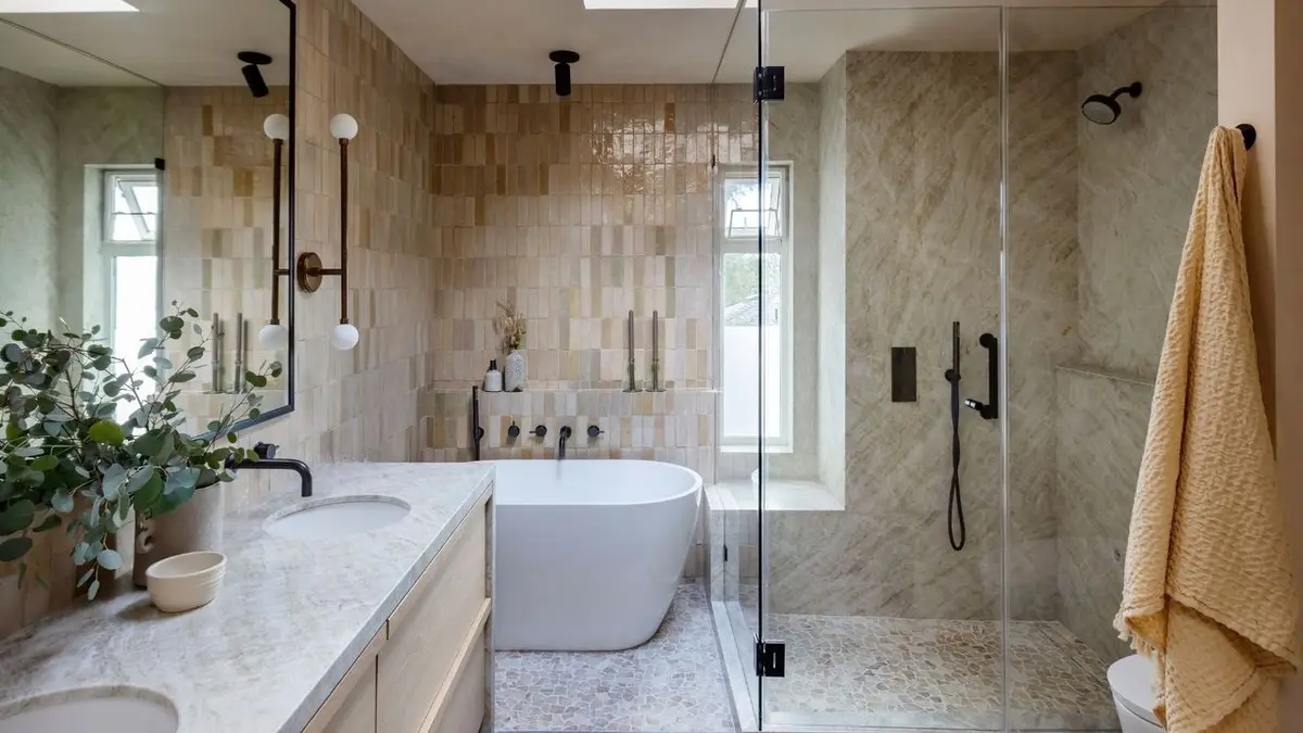 Modern bathroom with a freestanding tub, glass shower, and textured tile walls.