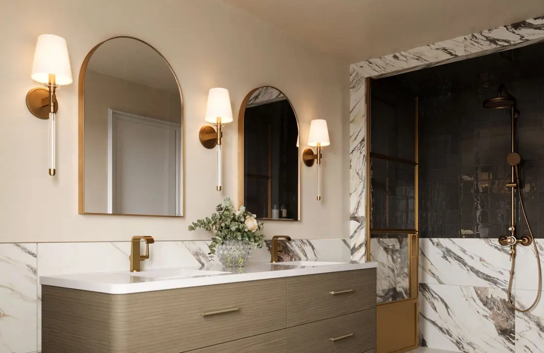 Elegant bathroom featuring a dual sink vanity with wall-mounted lights and a tiled shower area.