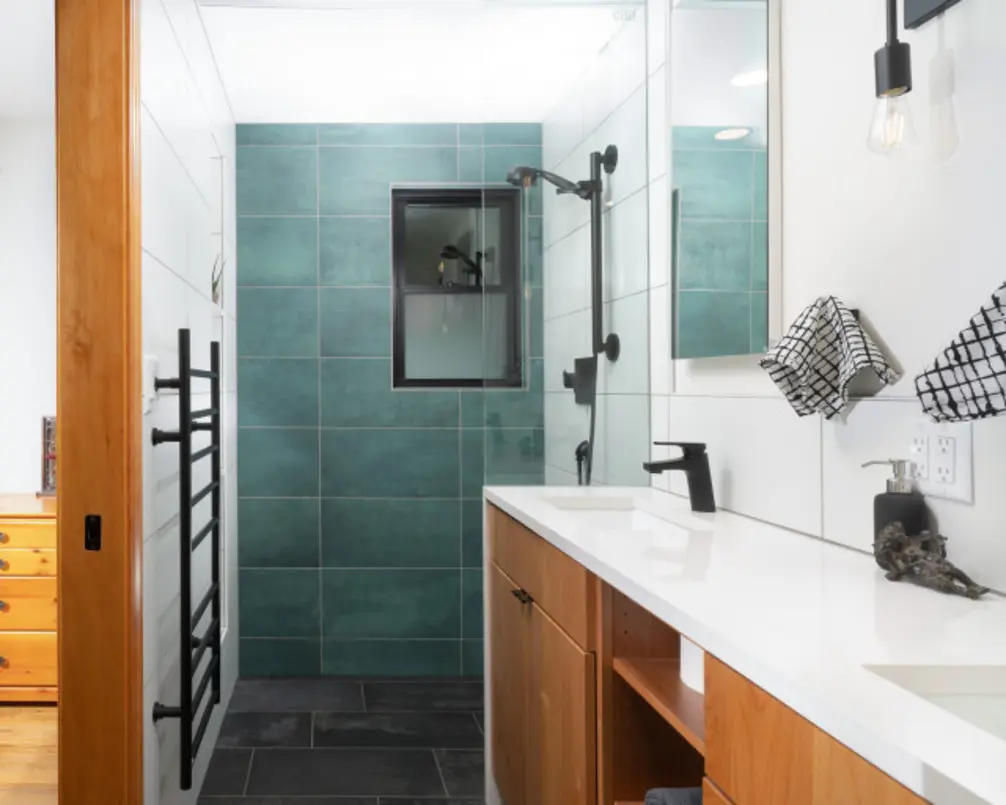 A heated towel rail with a towel hanging in a modern bathroom setting.
