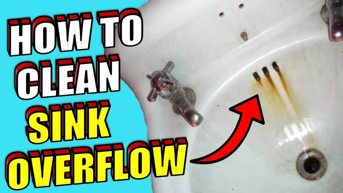 Cleaning a bathroom sink overflow with a small brush, showing rust stains and overflow opening.