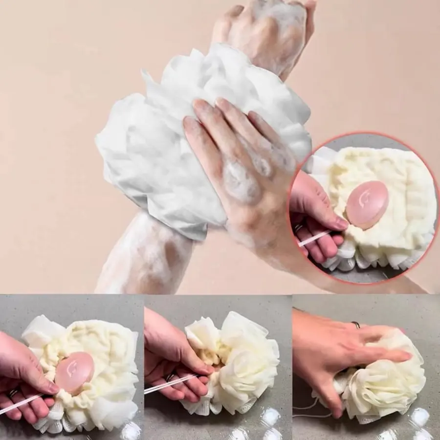 Hands holding a soapy shower pouf under running water, demonstrating a cleaning method.