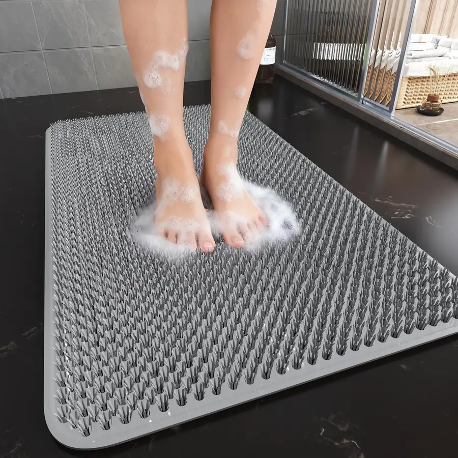 Feet standing on a textured silicone shower mat with bubbles and soap.