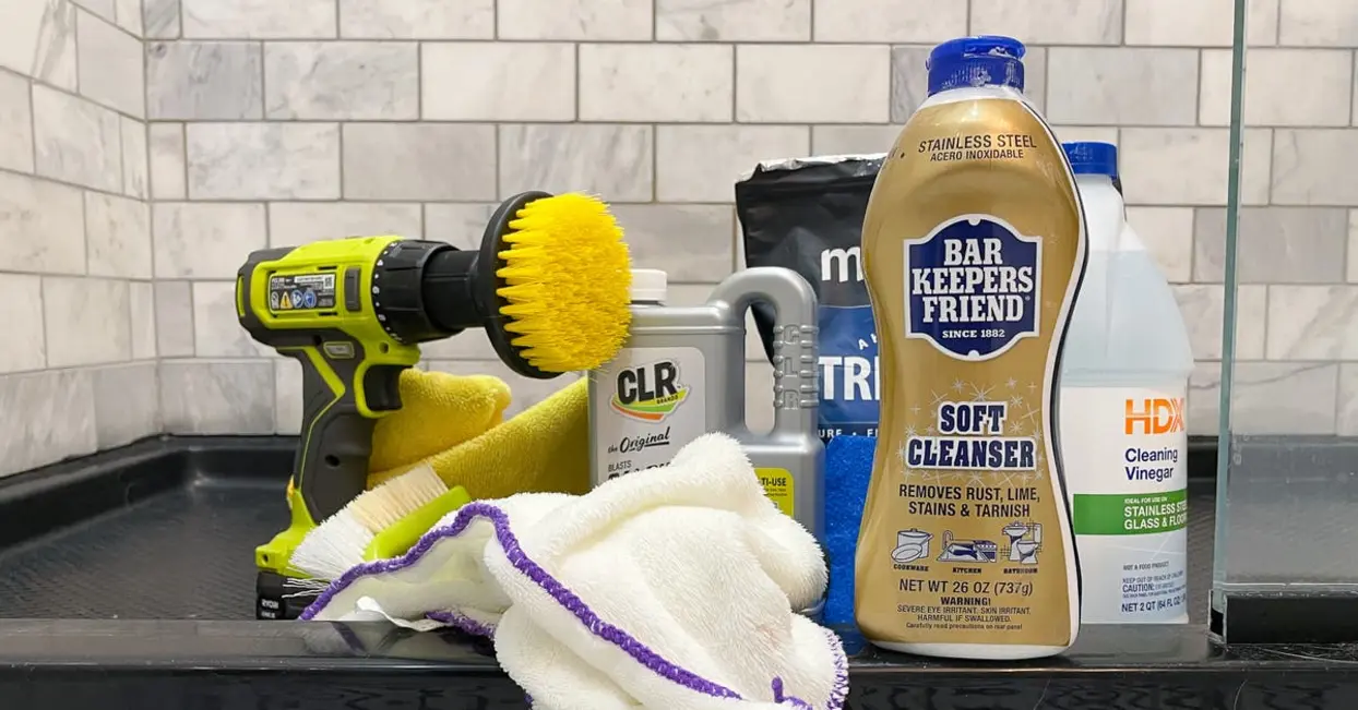 Cleaning tools and supplies on a countertop, including a drill, cleaning solution, and cloths.