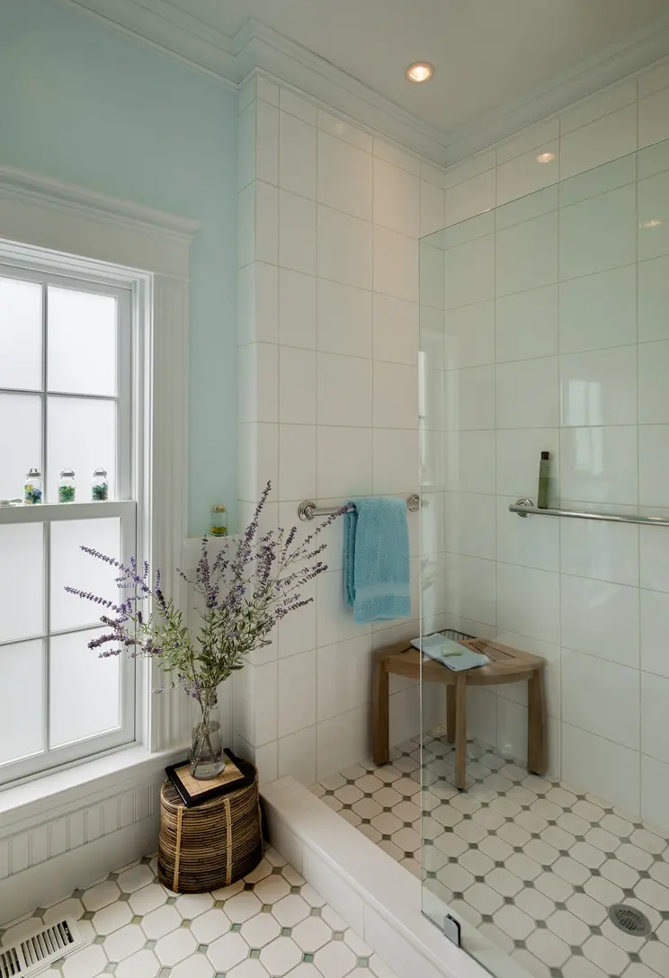 Modern bathroom with a glass shower, tiled walls, and a towel bar.