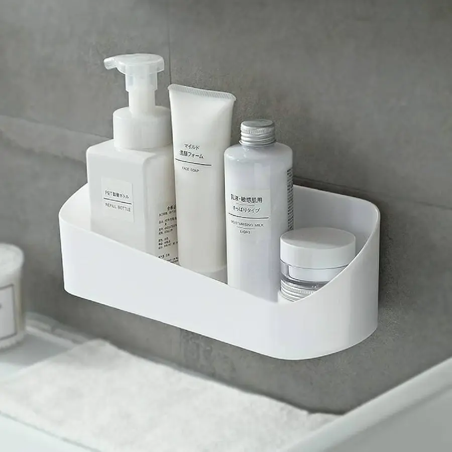 A white, wall-mounted shelf holding various bathroom products like soap and moisturizer.