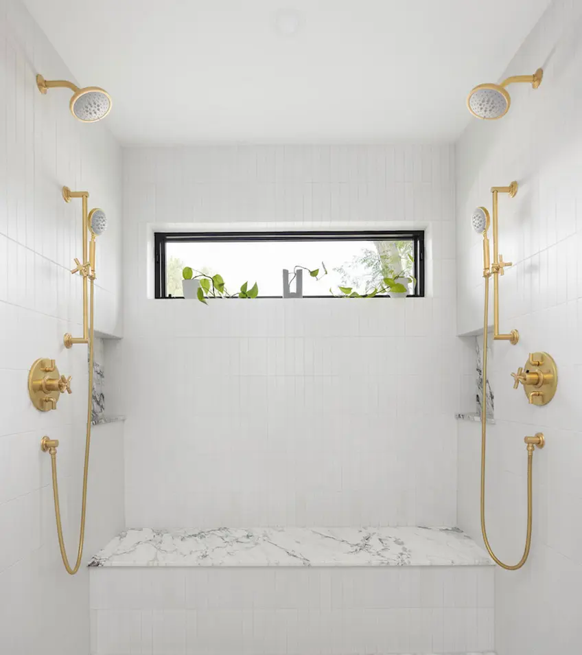 Luxurious shower with dual rain showerheads and a marble bench against a clean, white tiled wall.