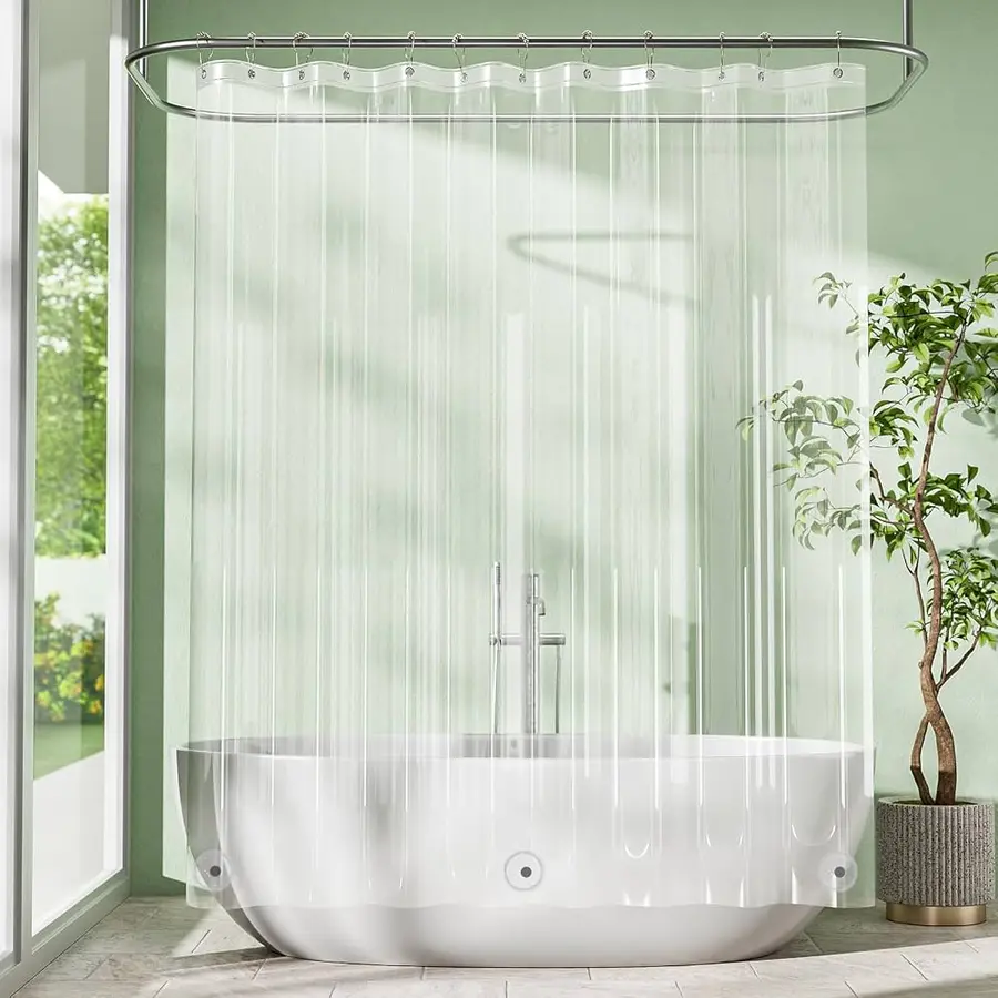 Clear shower curtain liner hangs in front of a modern bathtub in a bright bathroom.