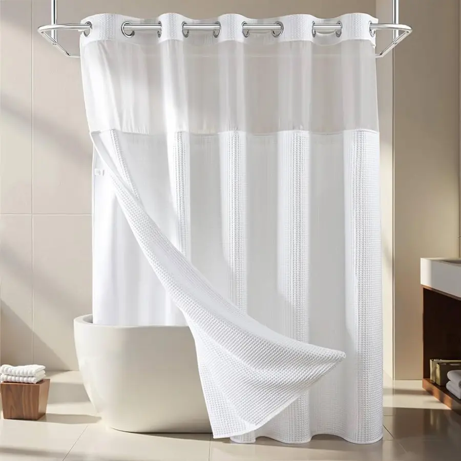 White shower curtain and liner separated, drying over a modern bathtub with neutral tiled walls.