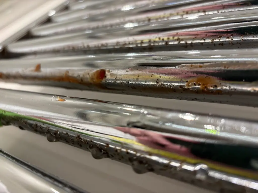 Rusty towel rail with visible corrosion and moisture accumulation.